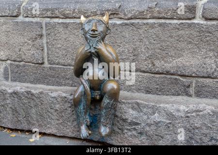 LUBECK, GERMANY - SEPTEMBER 23, 2025: This is a bronze sculpture of the "Little Devil of Lubeck" from the urban legend, sitting near the walls of St. Stock Photo