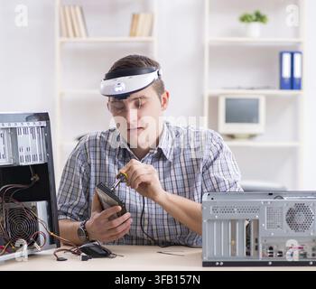 The young technician repairs computers in the workshop Stock Photo