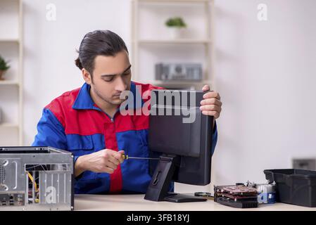 Young male mechanic repairs computer PC Stock Photo