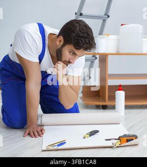 Mechanic does renovation repair in house with paper wallpaper Stock Photo