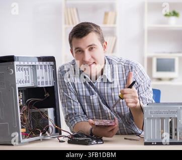The young technician repairs computers in the workshop Stock Photo