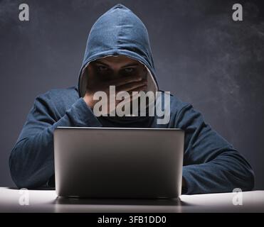 The computer hacker works in a dark room Stock Photo