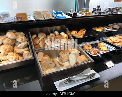 Assorted bread rolls and pastries at a hotel breakfast buffet in Hotel breakfast area, Rome, Italy. The image presents food, retail, and everyday trav Stock Photo