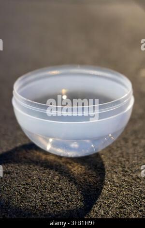 Transparent plastic container on textured surface. Stock Photo