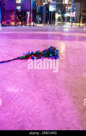 Colorful shredded paper resting on reflective floor. Stock Photo