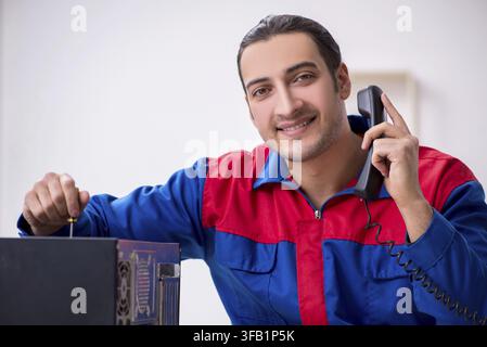 Young male mechanic repairs computer PC Stock Photo
