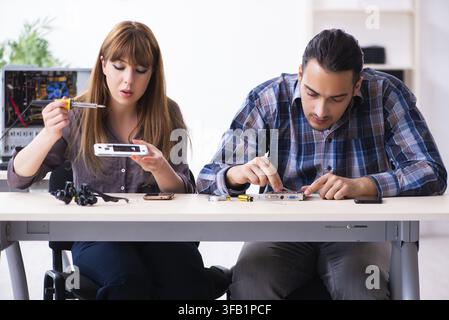 The two technicians who work in the computer warranty center Stock Photo