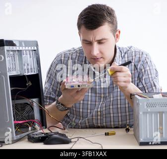 The young technician repairs computers in the workshop Stock Photo