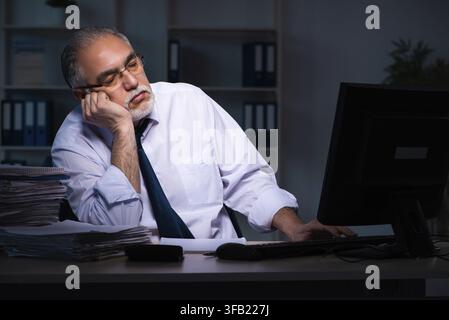 Old employee working late in the office Stock Photo