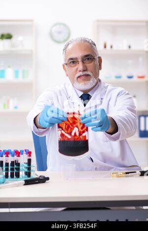 Old chemist working in laboratory Stock Photo
