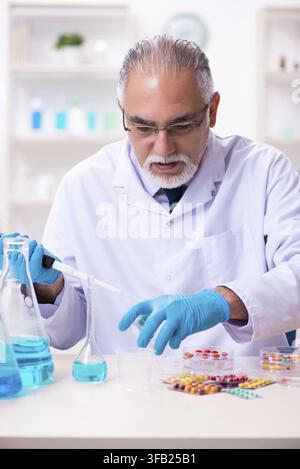 Old chemist working in laboratory Stock Photo