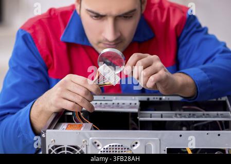 Young male mechanic repairs computer PC Stock Photo