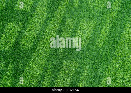 Close-up of lush green artificial grass with dense synthetic blades, creating a vibrant turf texture and seamless background. Stock Photo