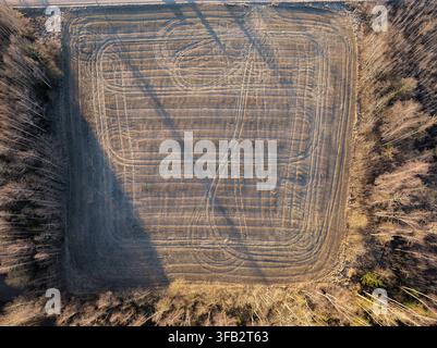 Top down drone view of cultivated farmland with geometric machinery tracks Stock Photo