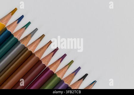 Macro close up of metallic colored pencils arranged diagonally in a row on white background with copy space Stock Photo