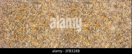 Golden brown granite stone surface showing natural textured pattern Stock Photo