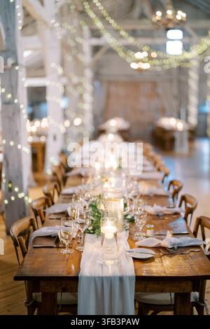 Elegant wedding dinner setup in rustic barn Stock Photo