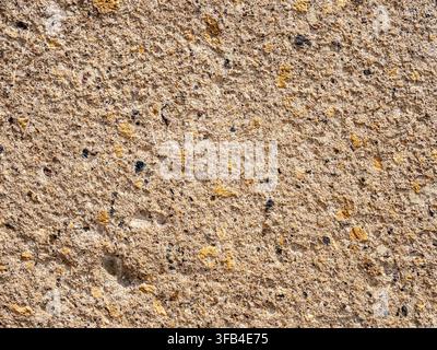 textured wall from orange armenian tuff stone of ancient church of Hovhannavank Monastery in Armenia lit by sun light Stock Photo