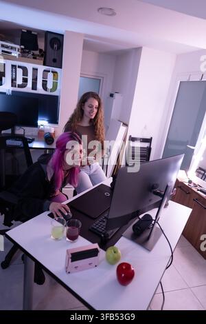 Two creative designers collaborating on a desktop computer in a modern workspace with stylish decor Stock Photo
