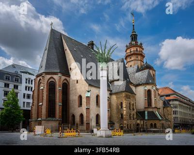 Historic St Nicholas Church in central Leipzig, Germany, photographed from the square beneath a dramatic blue and cloudy sky. The medieval and later r Stock Photo