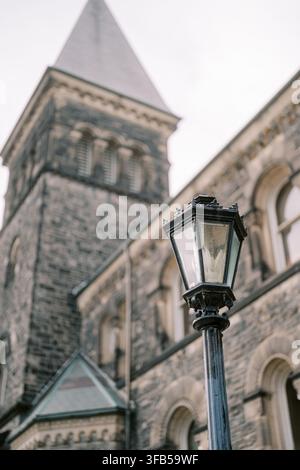 Historic stone building and vintage street lamp at University of Toronto Stock Photo