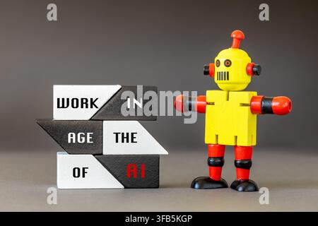 Work in the age of AI. Text on wooden blocks and yellow robot. Conceptual image of artificial intelligence impact on human workforce, jobs and career. Stock Photo