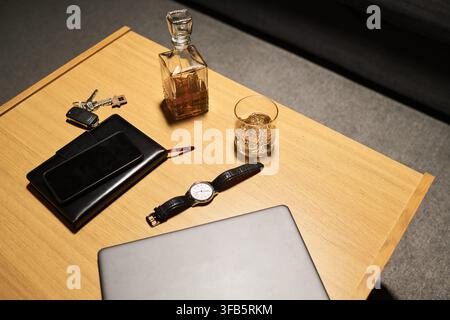 Alcohol Decanter and Glass on Table with Laptop and Car Keys Stock Photo