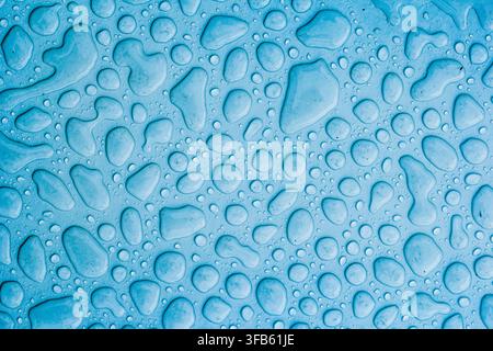 Caption: Blue water droplets forming an abstract surface texture background Stock Photo