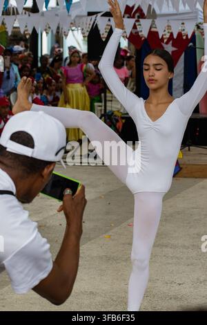 Man photographs a dancer performing in a white leotard at El Carnavalito in Ciego de Ávila, Cuba, on August 21, 2026. Stock Photo