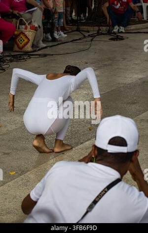 Man photographs a dancer performing in a white leotard at El Carnavalito in Ciego de Ávila, Cuba, on August 21, 2026. Stock Photo
