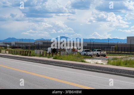 Eagle Mountain, Utah, USA. 22nd Aug, 2026. Vehicles sit parked near a construction zone alongside a perimeter fence at the Meta Eagle Mountain Data Center campus in Eagle Mountain, Utah, United States, on August 21, 2026. The massive technological infrastructure campus comprises multiple large-scale industrial buildings designed to house computing servers and process global network data traffic for Facebook's parent company, Meta Platforms, Inc. (Credit Image: © Charles McClintock Wilson/ZUMA Press Wire) EDITORIAL USAGE ONLY! Not for Commercial USAGE! Stock Photo