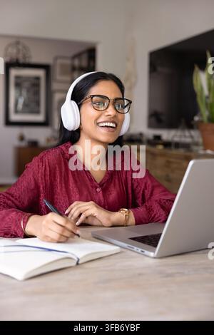 Woman engaged in online lesson or virtual meeting using laptop Stock Photo