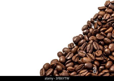 Roasted coffee beans clustered in the bottom right corner against a white background with copy space for text. Stock Photo