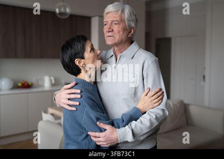 Senior anxious couple embracing comforting each other. Love support, health issues, emotional bond Stock Photo