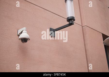 Surveillance camera and light on building wall Stock Photo