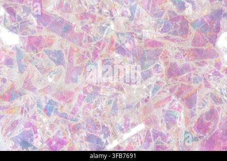 Abstract background of iridescent broken glass shards in pink, lilac and pale blue tones, shot close up with soft light and shimmering pearlescent Stock Photo