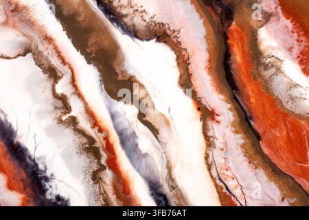 Abstract fluid art painting with flowing rust orange, brown, black and white layers forming marbled agate like patterns, a close up alcohol ink Stock Photo