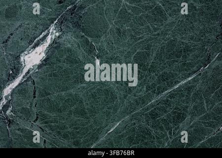 Polished dark green marble stone slab texture with fine white and grey veins, natural mineral pattern used as a luxury interior background surface Stock Photo