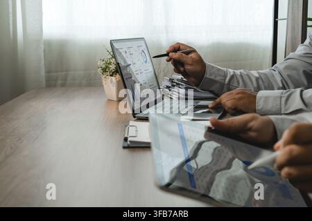 two businessmen discussing accounting data on laptop and tablet during financial consultation, reviewing dashboard charts and reports for business pla Stock Photo