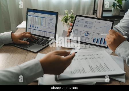 Business team analyzing review financial charts on a laptop reports, comparing figures and reviewing performance data for business analysis, reporting Stock Photo
