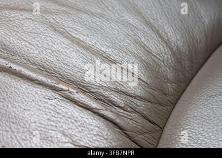 A leather texture close up showing beige upholstery, natural grain, creases, seam, and soft neutral surface detail for material design and interior us Stock Photo