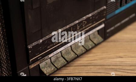A detailed macro photograph highlights the corroded cassette buttons of an antique portable stereo system. The playback switches are thickly coated in Stock Photo