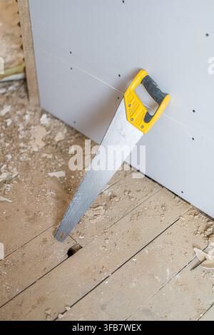 Hand saw and construction tools on floor during home renovation Stock Photo