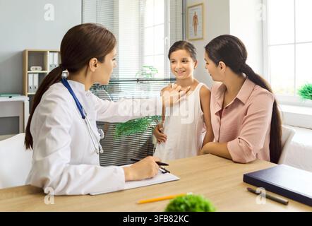 Pediatric checkup conversation with mother and daughter in bright clinic office Stock Photo