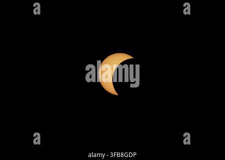View of the crescent sun during the partial solar eclipse phase with visible sunspots on the solar disk in Alcaniz, Aragon, Spain on August 12, 2026 Stock Photo