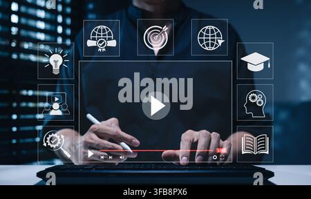 Online education and e-learning concept. Person using computer with icons representing online education, learning, knowledge sharing, educational tool Stock Photo