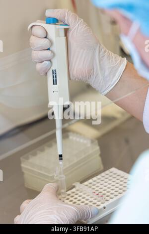 Laboratory Technician Using Micropipette for Sample Preparation Stock Photo