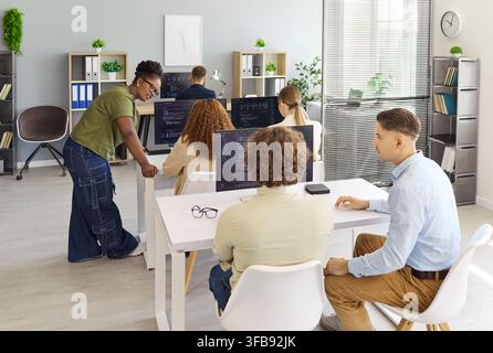 Programmers and developers collaborating on code in office during team meeting Stock Photo