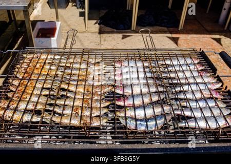 Fresh sardines being grilled on a barbecue grill, street food, Lisbon, Portugal Stock Photo