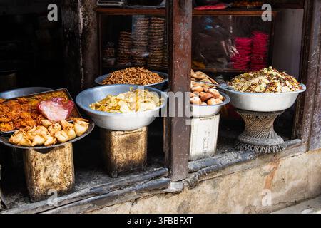 Four large bowls of street food in a poor section of Varanasi India on a porch stoop. Stock Photo